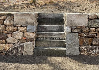 Reclaimed Granite Steps through a New England Fieldstone Wall